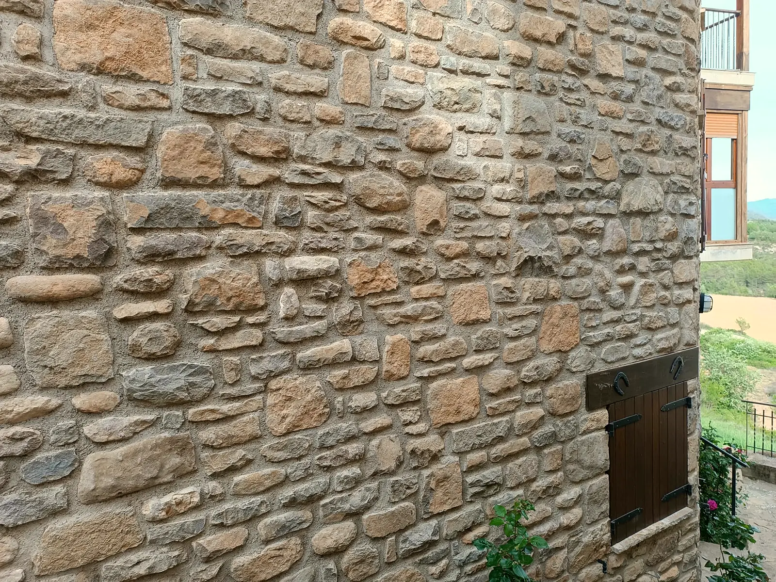 Detalle del muro de piedra con portezuela de madera