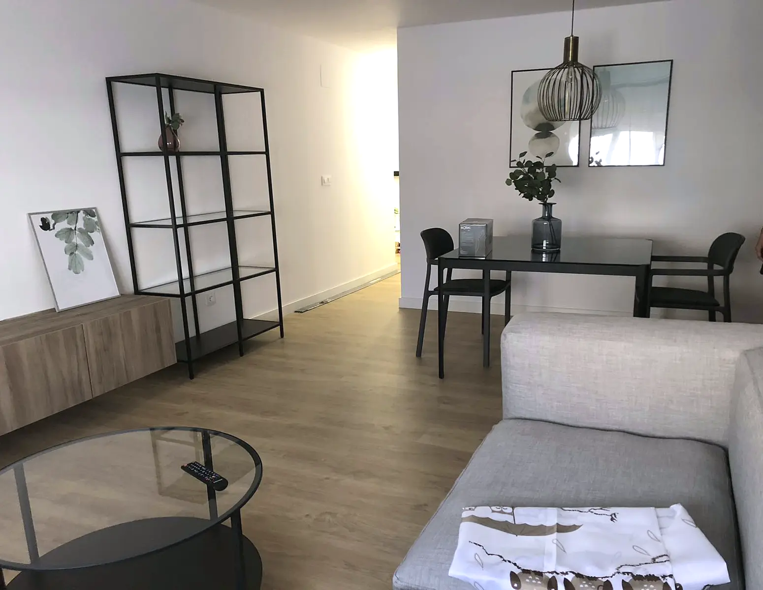 Salón comedor reformado con suelo de madera y cocina abierta